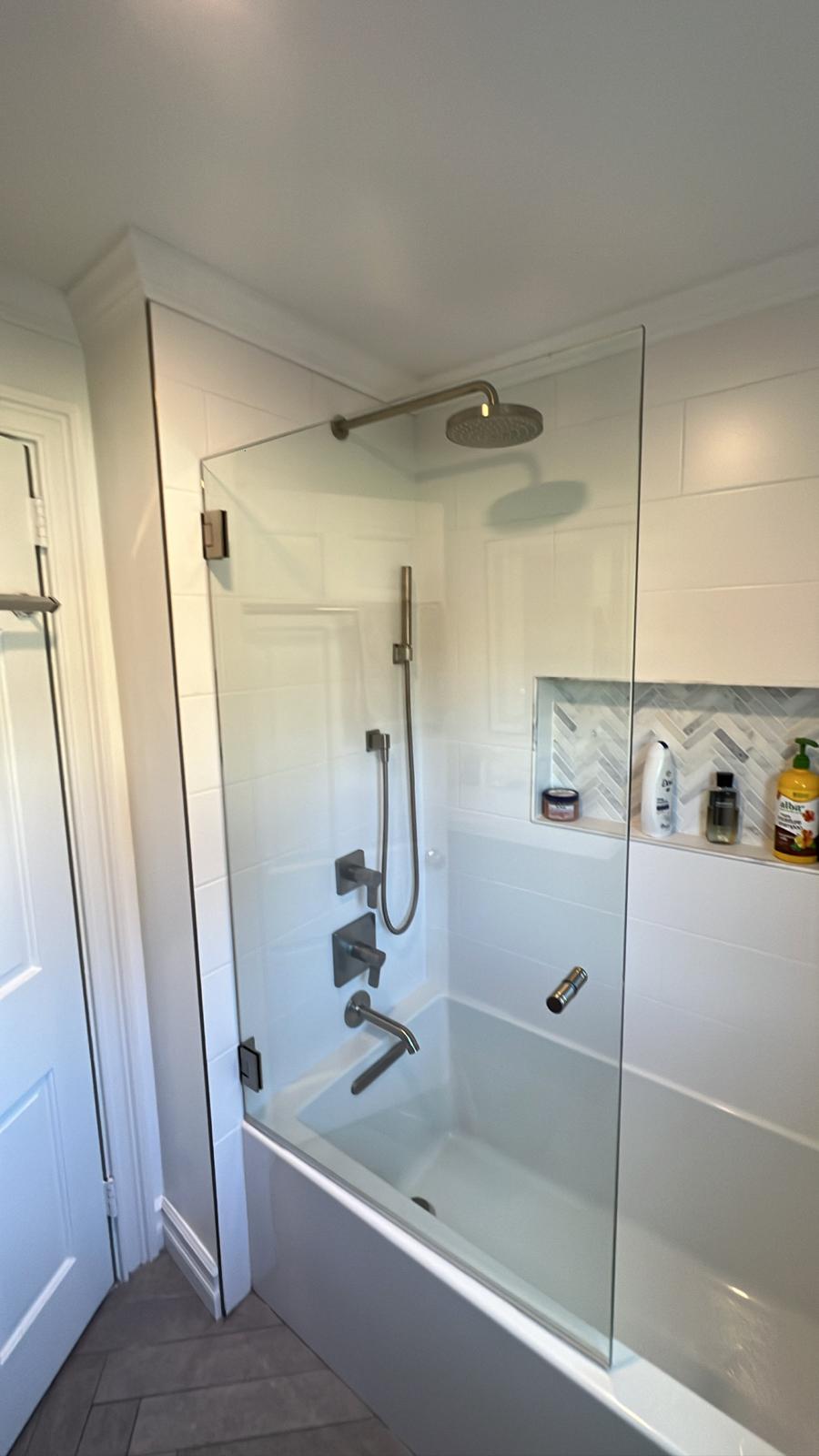 Freshly cleaned bathroom with white subway tile and black framed shower door