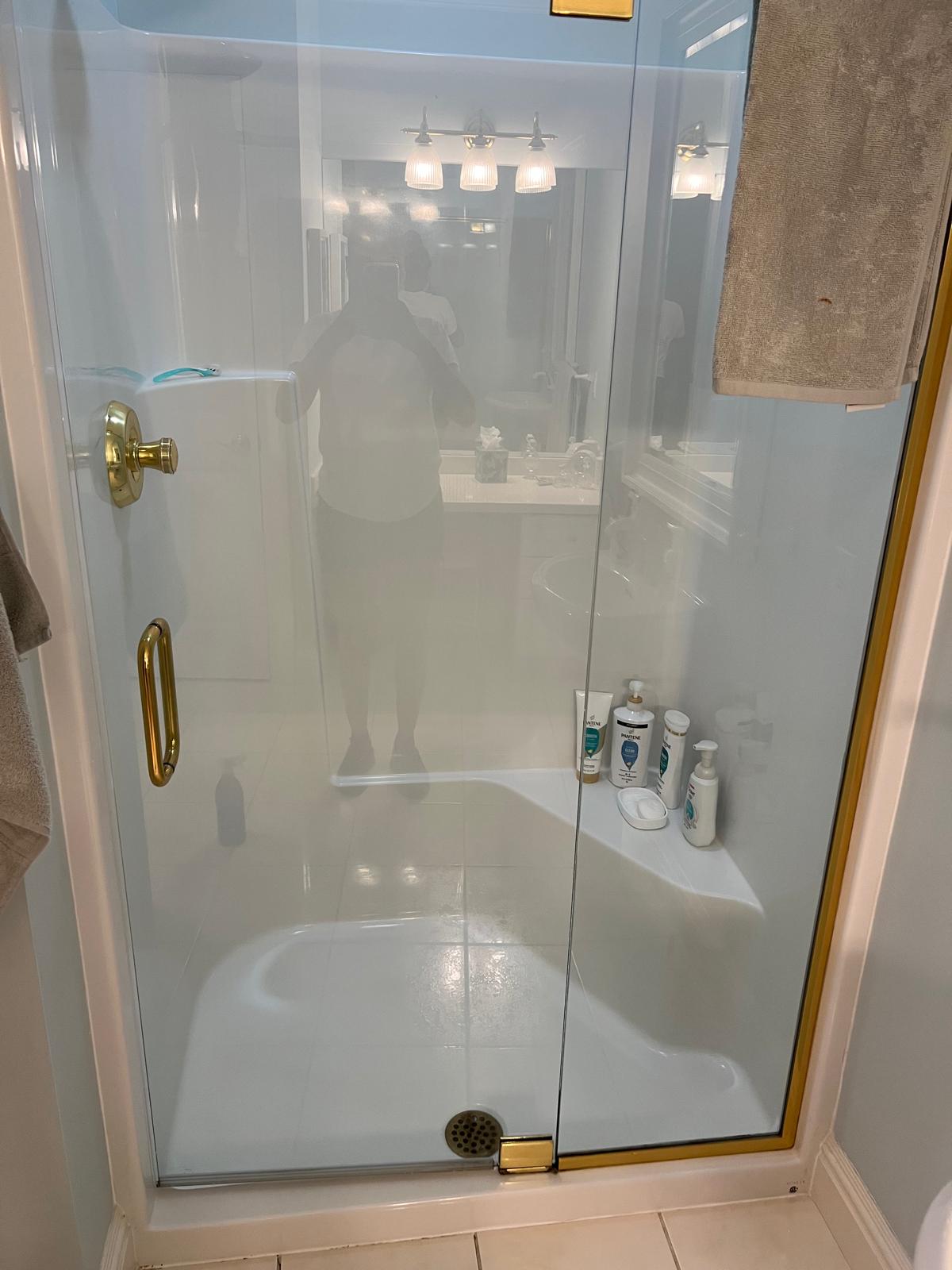 Clean white bathtub and glass shower panel after a residential cleaning